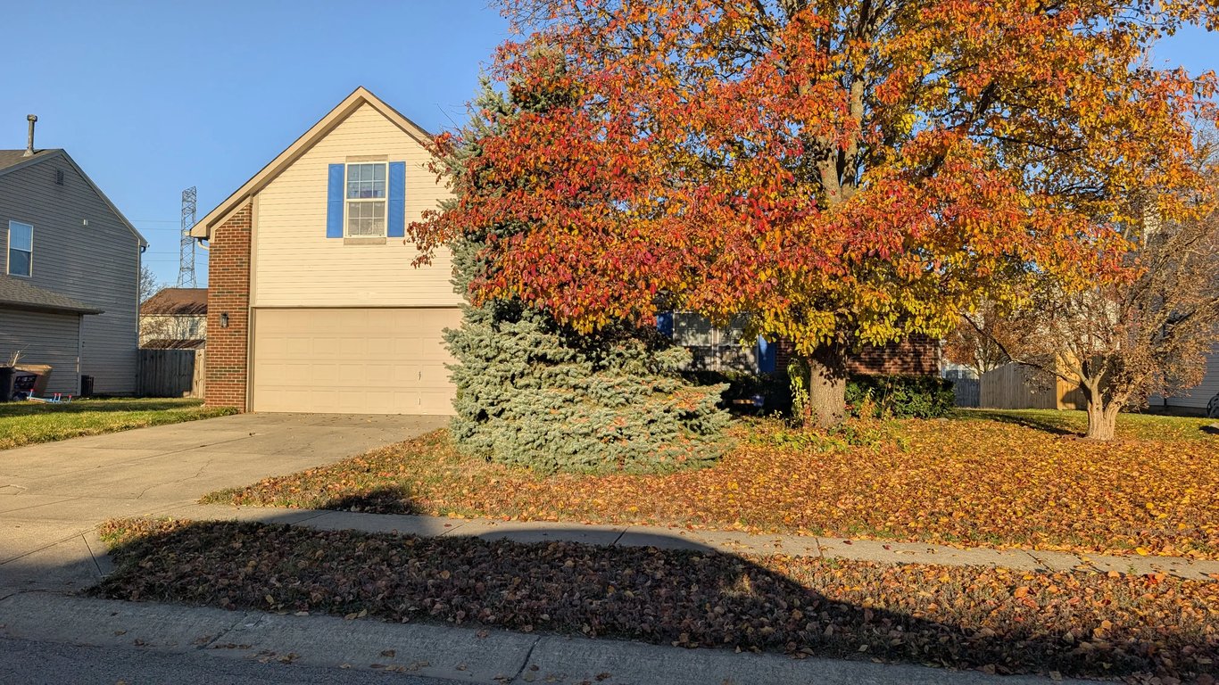 2012 Louisville home with partial brick exterior and heavy overgrowth, sold in foreclosure condition