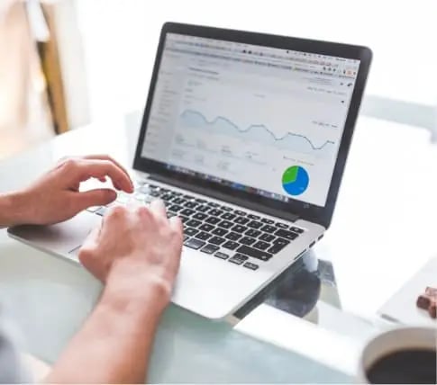 Hands typing on laptop preparing a cash offer for a homeowner selling their house as-is