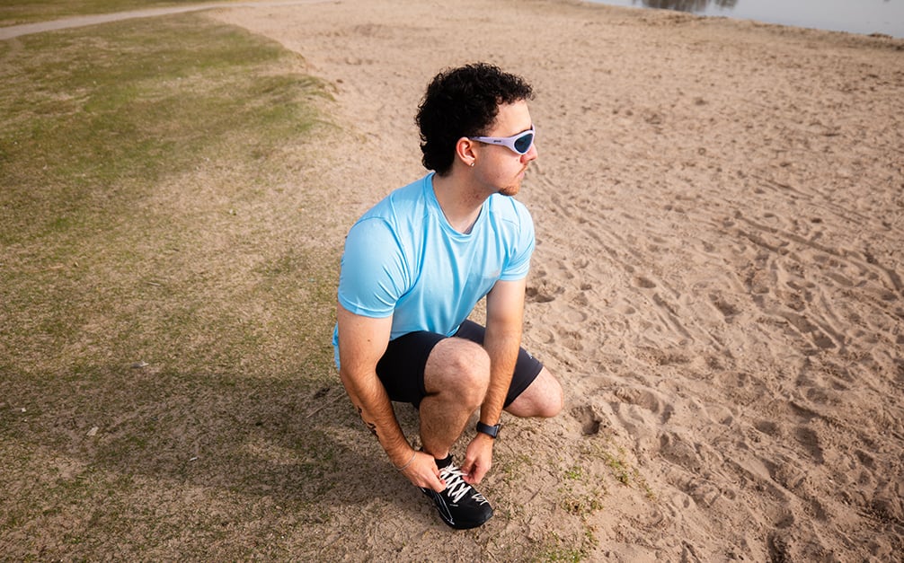 Hardloper strikt veters van schoenen op het strand.