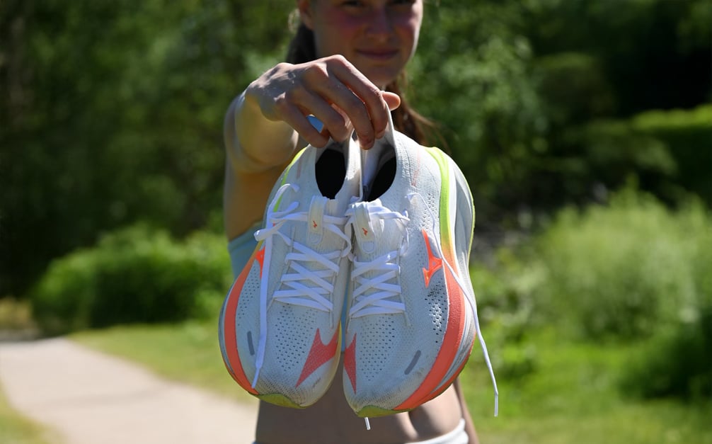 Hardloper toont witte Mizuno Neo Vista 3 met neon kleuren tijdens hardlopen