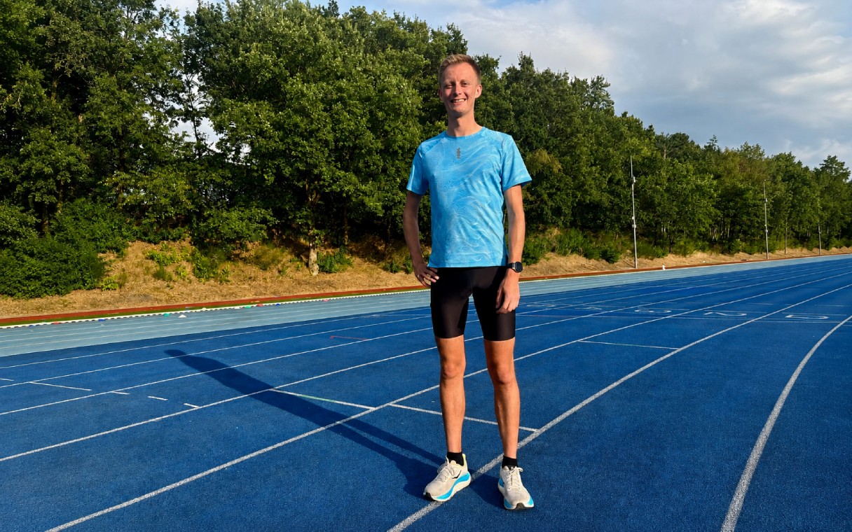 hardloop ambassadeur in blauw loopshirt op blauwe atletiekbaan