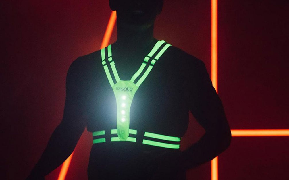 hardloper die een reflecterend vest draagt in het donker dat oplicht