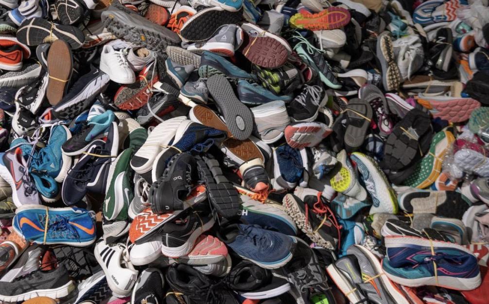Grote afvalberg met oude hardloopschoenen die kunnen worden gerecycled