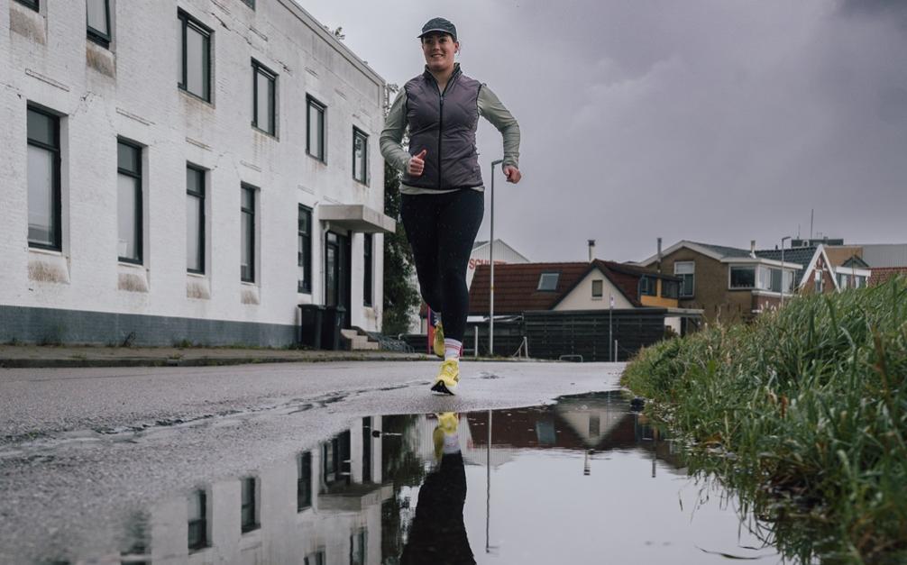 Hardloopster die bijna in een regenplas trapt.