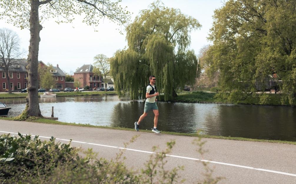 Hardloper die rent in de hitte langs het water in Leiden.