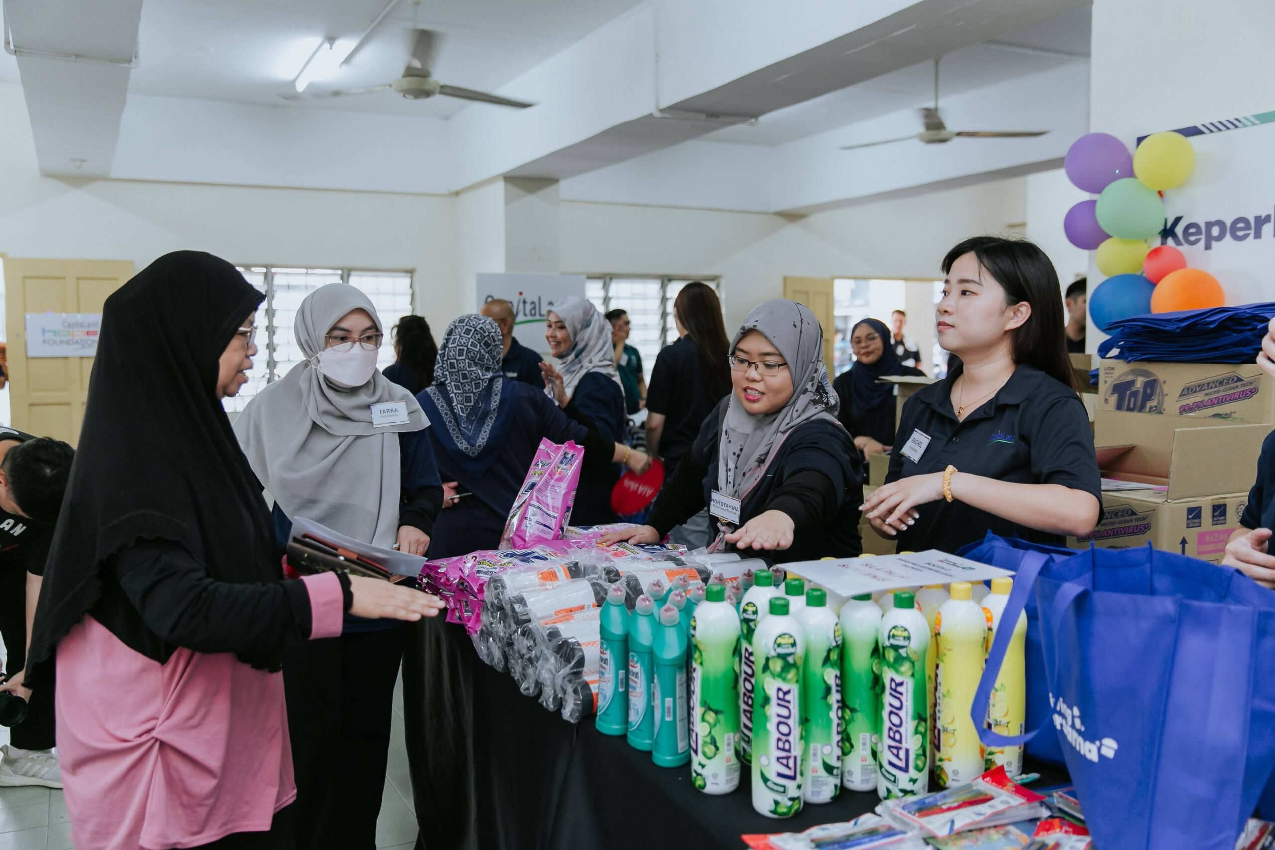 Beneficiaries choosing from an assortment in the community hall at PPR Sri Pantai, Lembah Pantai 2