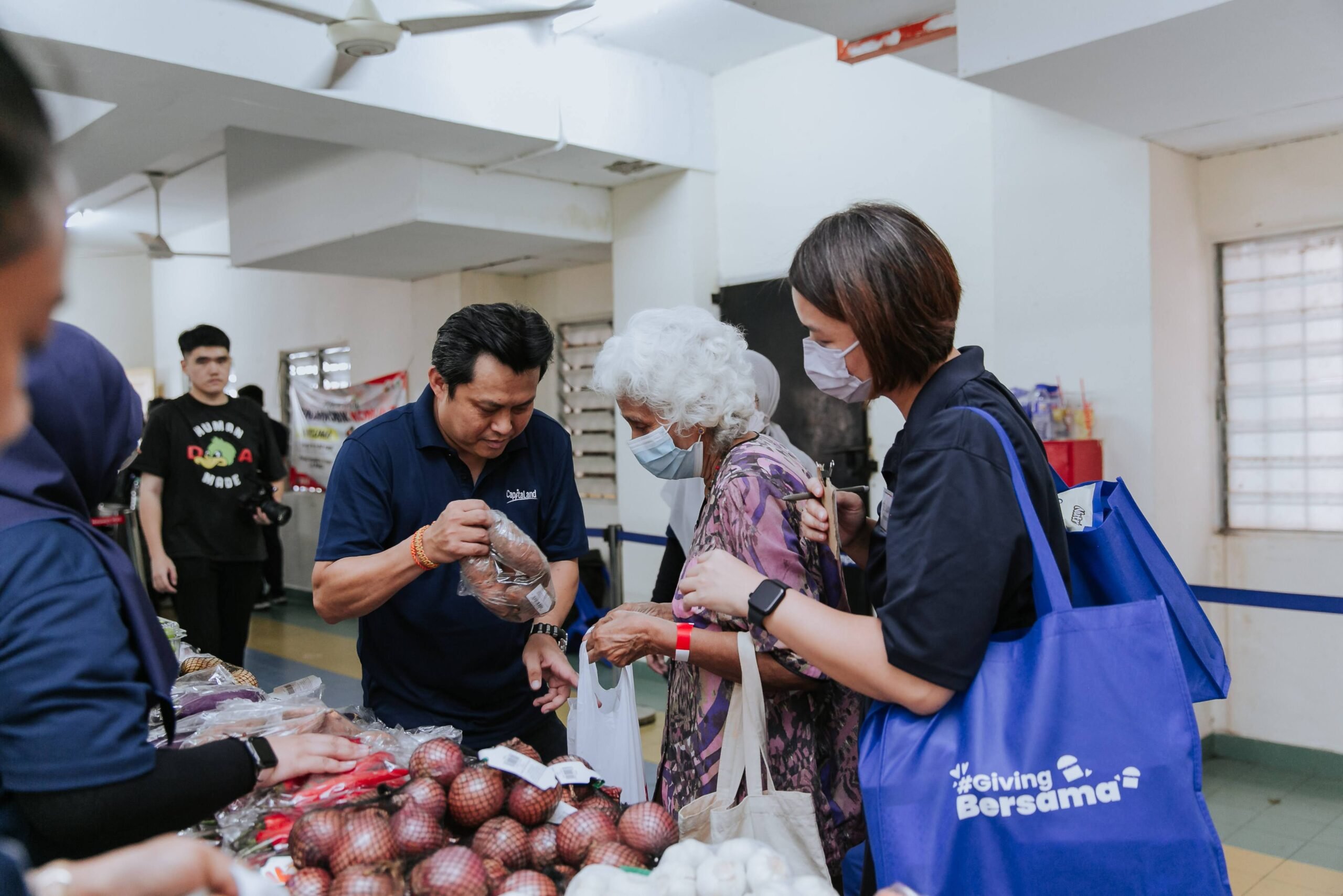 Beneficiaries choosing from an assortment in the community hall at PPR Sri Pantai, Lembah Pantai 1