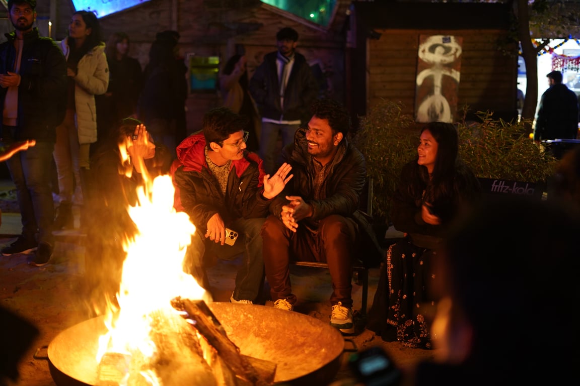 Diwali in Berlin nach Einbruch der Dunkelheit — Gäste wärmen sich am Lagerfeuer im Jules B-Part, Kreuzberg