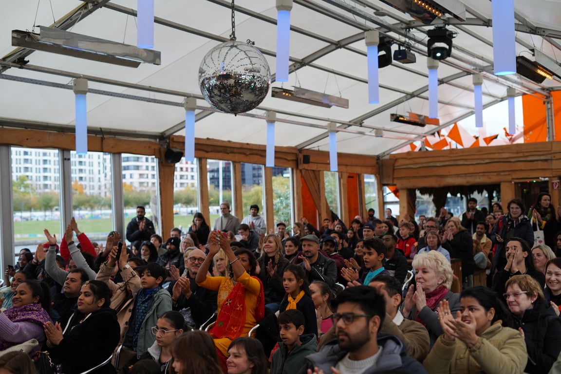 Vielfältiges Publikum klatscht während eines Auftritts bei Diwali in Berlin — Familien, Freunde und Berlins Diaspora in einem Raum