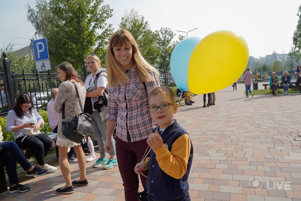 Діти одягнені у вишиванки та форму, в руках квіти та кульки