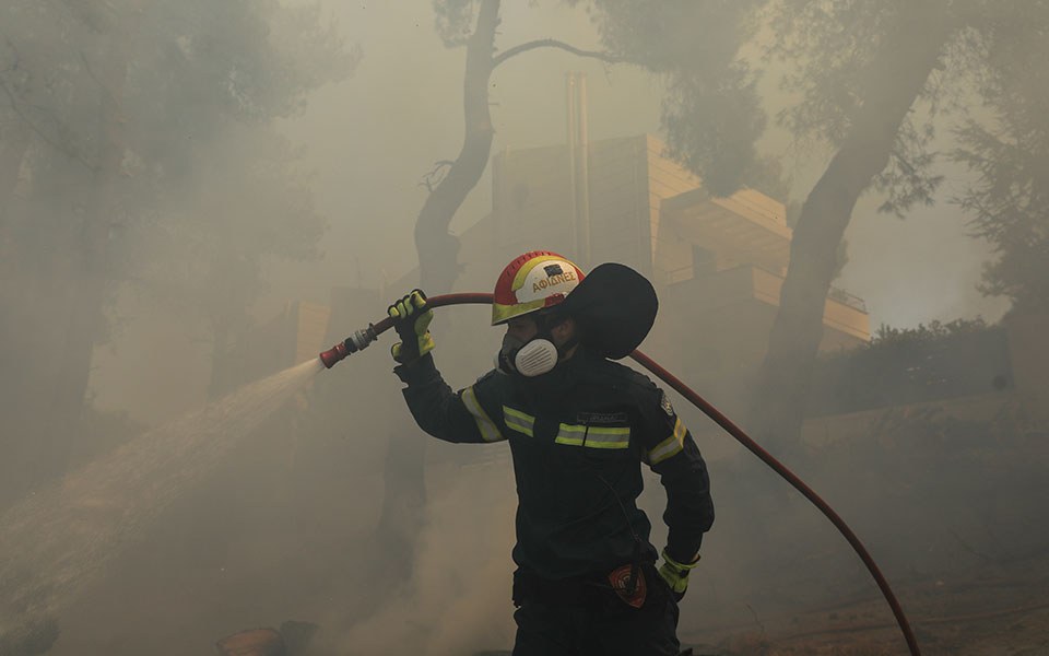 Пожежник гасить вогонь у Греції