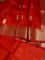 Orangish Red Premium Kora Banarasi Saree with heavy weaving borders and Raw mango style motifs