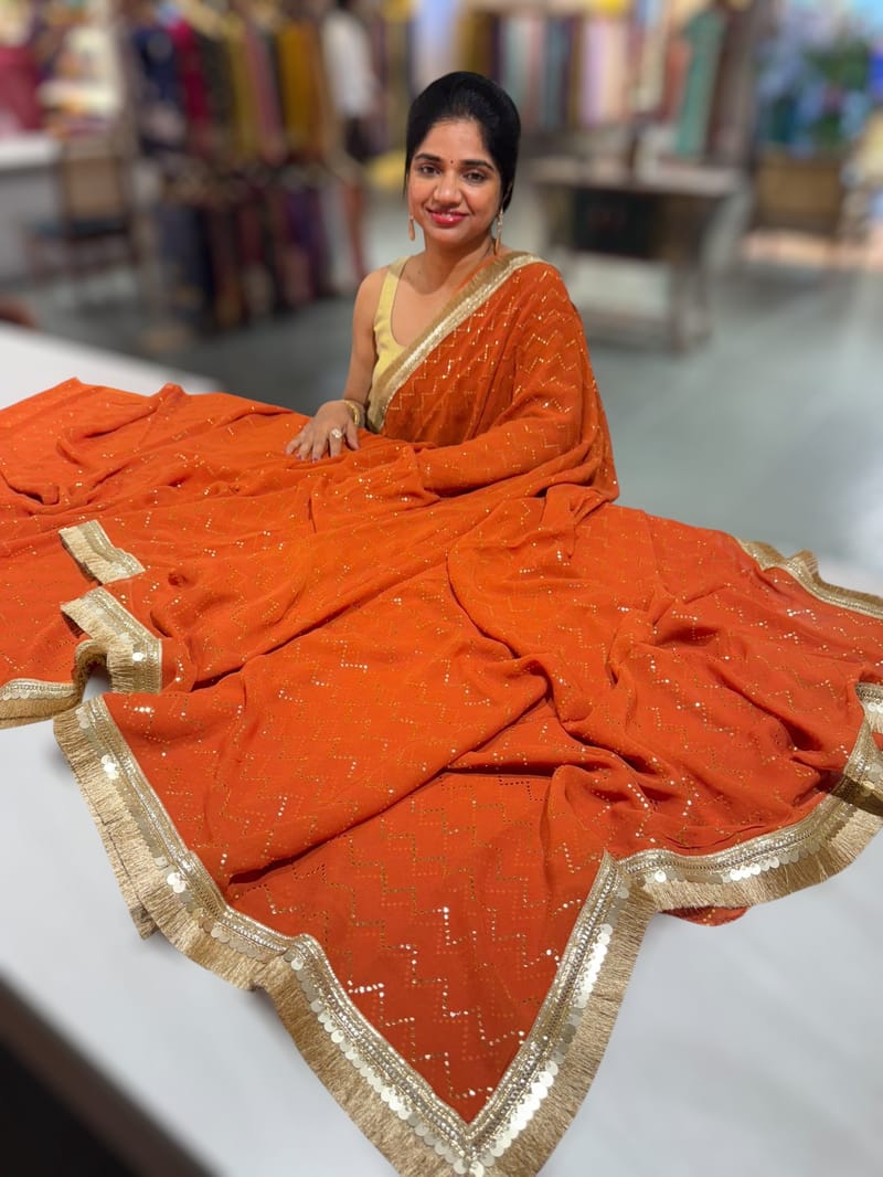 Rust Orange Georgette Saree with stick on Badla in zigzag pattern