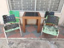 Mesa de madera fija (con detalles) medidas 70,5x70,5x75 cms. + 4 sillas de plásticos con estructura de metal 