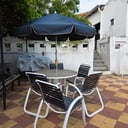 Mesa circular de base de acrílico con estructura de metal + 5 sillas de jardín con estructura de metal + Sombrilla grande para el sol 