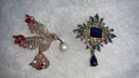 DOS PRENDEDORES UNO DE AVE EN CIRCÓN ROJO RUBÍ Y DIAMANTES CON PERLA, OTRO EN AZUL TIPACIO Y DIAMANTES