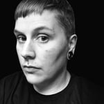 A black and white photo of a straight edge woman looking into the camera