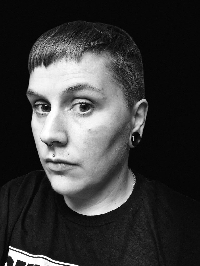 A black and white photo of a straight edge woman looking into the camera