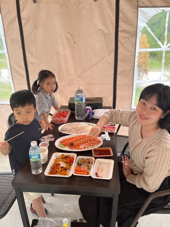 글램핑 다이닝 텐트에서 시푸드를 즐기는 엄마와 아이들