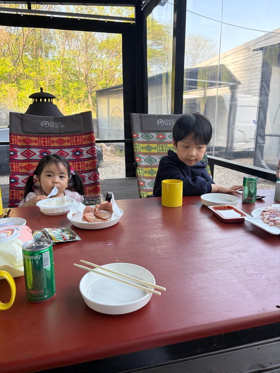 포천 더클래식카라반 테라스에서 8세 남아와 5세 여아가 바베큐 저녁식사를 즐기는 모습