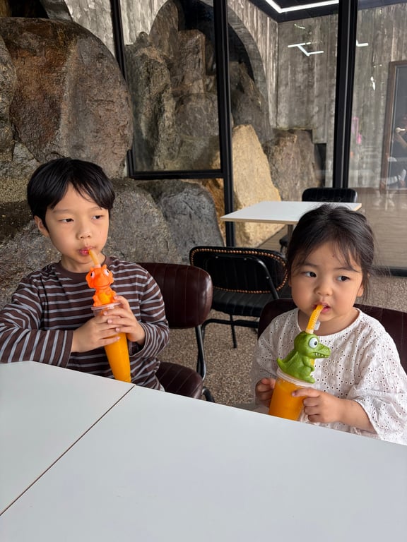 카페에서 공룡 모양 슬러시를 함께 마시는 남매