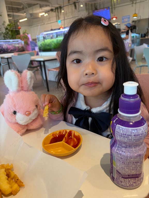 쥬라리움 하남점 카페에서 핑크 토끼 인형을 안고 카메라를 바라보는 귀여운 아이