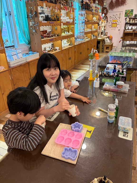 허브아일랜드 DIY 체험장에서 엄마와 남매가 비누만들기 체험 중인 모습
