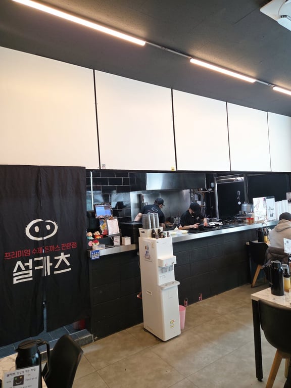 설카츠 가게 내부 오픈 주방과 블랙 인테리어