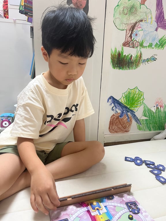 보드게임에 진지하게 집중하는 남자아이 — 토이배틀 플레이 중