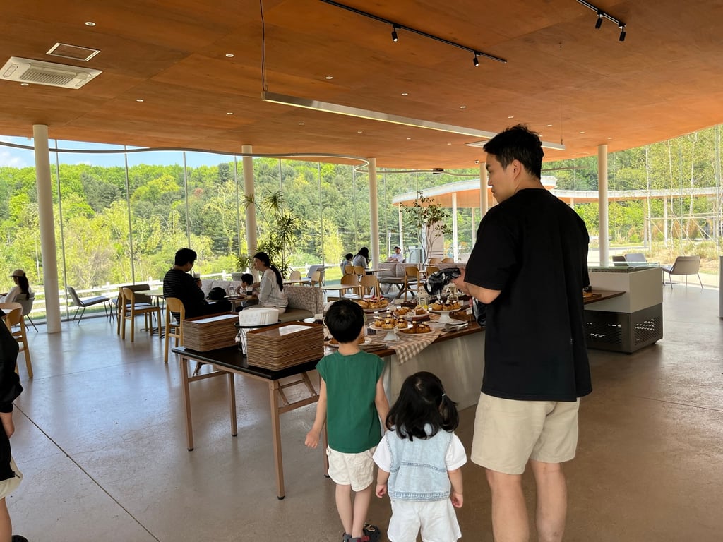 Cloud Hill 카페 통유리 내부에서 바라본 빵 진열대와 가족