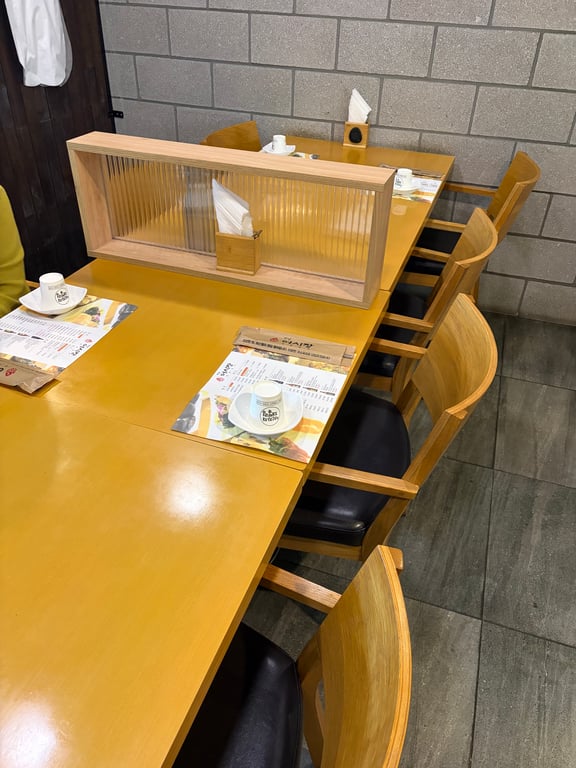 하남 어시장 테이블 세팅 — 노란 테이블과 메뉴판