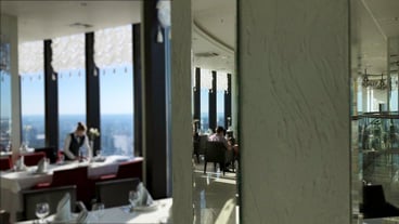 Reflection in mirror of family enjoying meal in restaurant together back view of happy family having