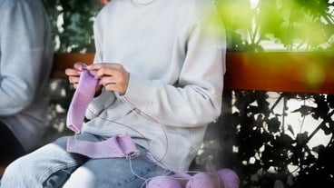 Young adult knitting outside