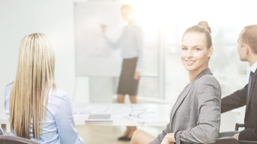 Concetto di business e ufficio: donna d'affari sorridente con il suo team in ufficio.