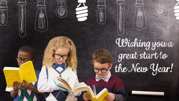 Children reading books against blackboard with 2017 new year greeting quotes