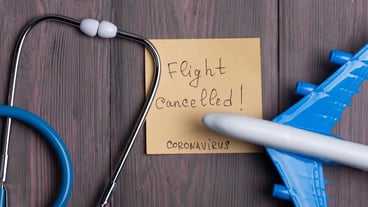 Text flights cancelled Coronavirus on sticky note stethoscope and airplane model