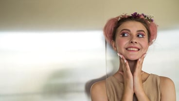 Close-up of a beautiful young lady in a beige dress and professional make-up posing for the camera