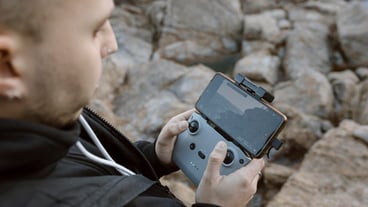 Young man operating a drone over the sea High quality photo