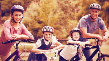 Portrait of happy family on bicycle at park