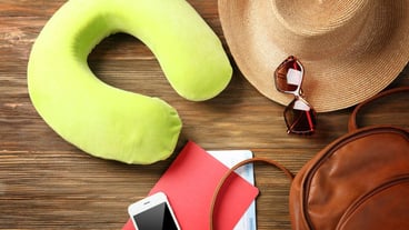 Travel cushions and travel utensils on a wooden background