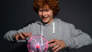 Medium shot guy interacting with a plasma ball.