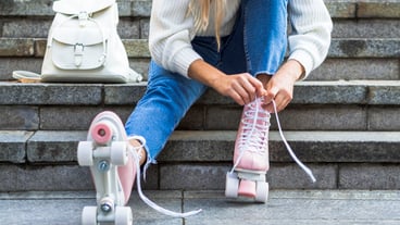 Woman on stairs tying shoelaces on roller skates