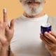 Front view of senior man with beard holding moisturizer