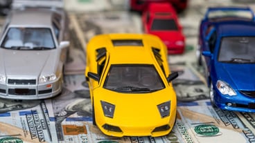 Toy car set on background with US dollar bills