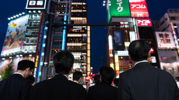 Rear view of people walking in city at night