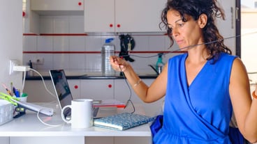 Working day in the home office. Girl works at home behind her laptop with headphones and a cup of coffee.