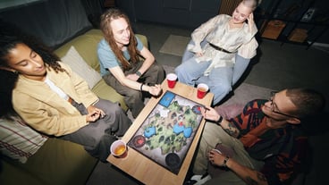 Young people play a board game at a party at home