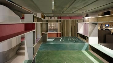a room with shelves and a green floor with a red and white box on the bottom