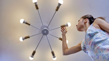 Replacing light bulb in led lamp by woman indoors