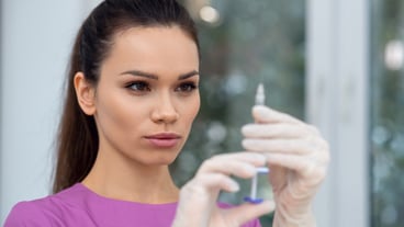 Young doctor using a syringe in a clinic
